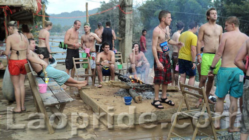 Tourists relax in front of a wood fire in Vang Vieng, Laos