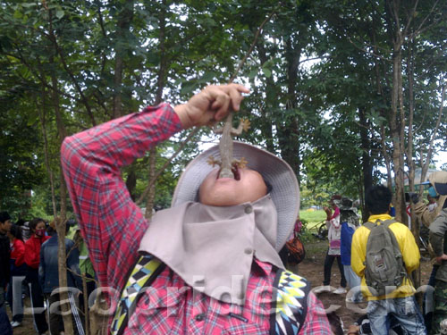 Lao boy eating a lizard