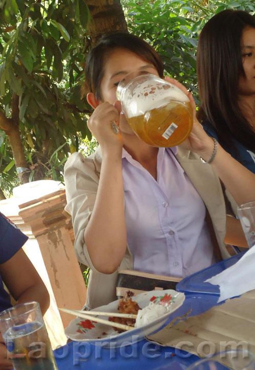 Lao schoolgirl drinking Beerlao
