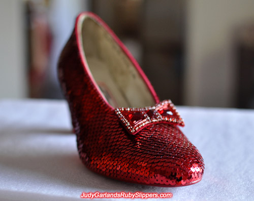 Sequining work is finished with one shoe on Judy Garland's ruby slippers