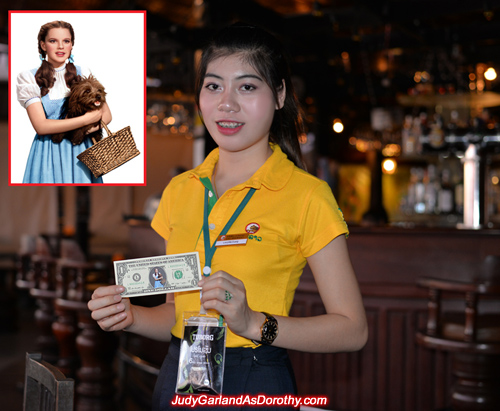 Beerlao girl holds Judy Garland as Dorothy's one dollar bill