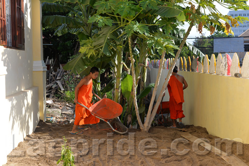 Buddhist monks are hard at work at the temple in Vientiane, Laos