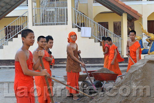 Buddhist monks are hard at work at the temple in Vientiane, Laos