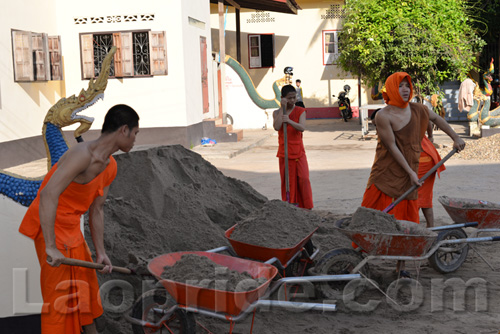 Buddhist monks are hard at work at the temple in Vientiane, Laos