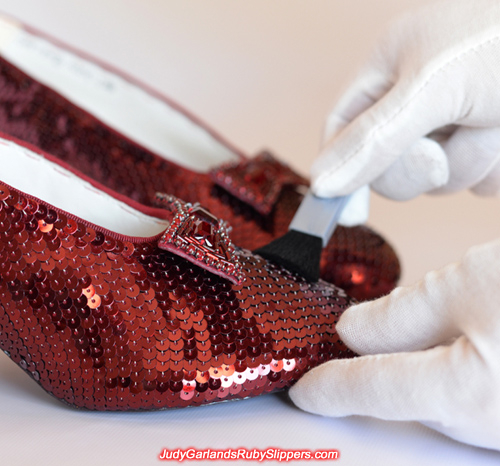 Wiping away dust particles on Judy Garland's ruby slippers