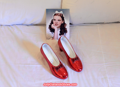 Judy Garland's hand-sewn ruby slippers on a bed